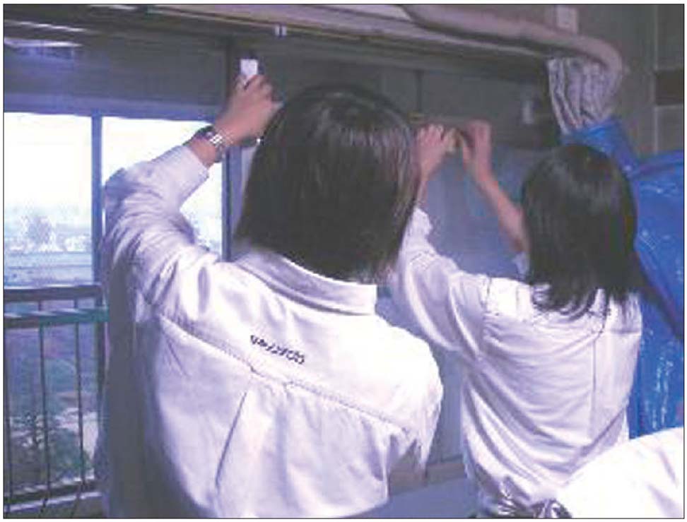 写真15　早稲田地区における防災まちづくり活動：高齢者の住宅にガラス飛散防止フィルム貼りを支援