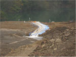 河道閉塞の決壊を防止するための緊急排水作業の写真