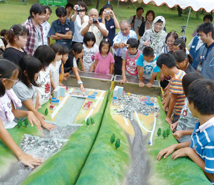 模型を使って土砂災害の仕組みを学ぶ、長崎県島原市安中地区の小学生。