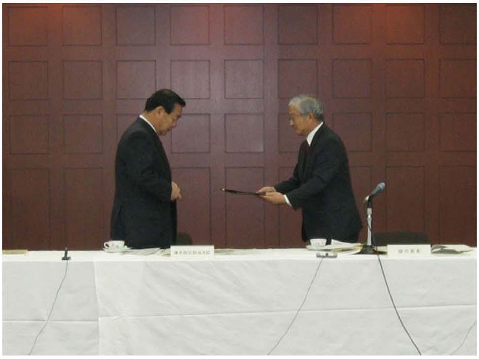 写真11　樋口座長から溝手防災担当大臣へ報告書手交