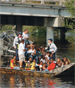 ハリケーン・カトリーナによる浸水からボートで救出される人々の写真