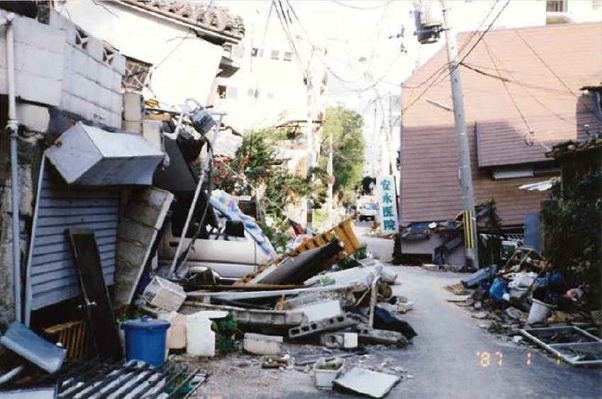 震災直後の備後町5丁目付近の様子。家屋が大きく傾き、ブロック塀が崩れるなど、地震の威力の凄まじさが見て取れます。