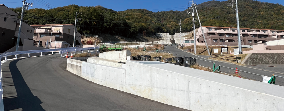 広島市八木地区の県営緑丘住宅付近の土砂災害被災後の平成26年(写真上)と現在(令和4年(写真下))の比較。土石流が通りやすい谷筋は住宅を建てず道路として利用しており、背後には砂防堰堤が築かれている。