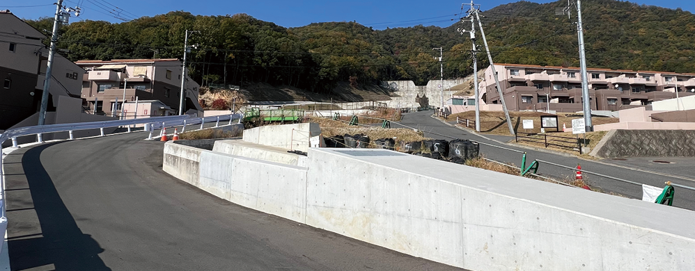 広島市八木地区の県営緑丘住宅付近の土砂災害被災後の平成26年（写真上）と現在（令和4年（写真下））の比較。土石流が通りやすい谷筋は住宅を建てず道路として利用しており、背後には砂防堰堤が築かれている。