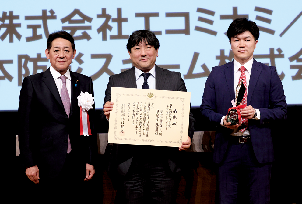 株式会社エコミナミ・日本防災スキーム株式会社の佐藤代表取締役(中央)と松村大臣