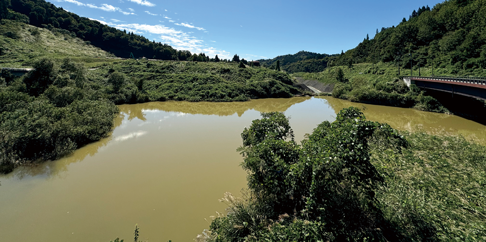現在の東竹沢地区の河道閉塞跡。写真中央の平坦な部分が地すべり堆積塊。その右手には放水用の水路が開削されている。(2024年9月撮影)