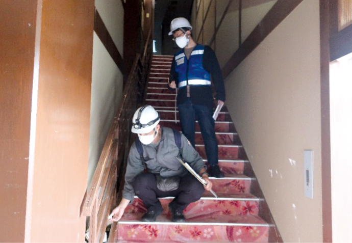 写真1 非住家建物(ホテル)の調査を行う不動産鑑定士(左)(令和6年4月27日七尾市にて、鑑定士協会連合会撮影)