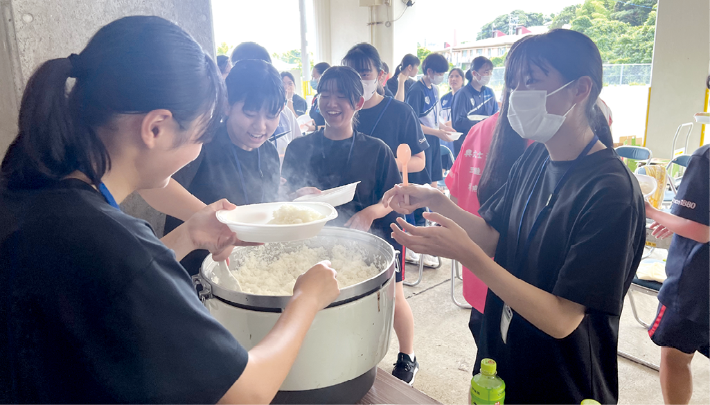 避難所での炊き出しを想定しライスをよそう生徒たち(令和6年(2024年)7月撮影)