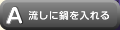 流しに鍋を入れる