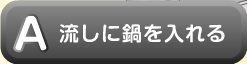 流しに鍋を入れる